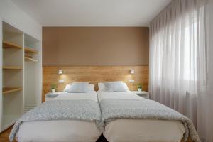 1 dormitorio con 2 camas y ventana grande en Hostal-Restaurante LUGANO, en Verín