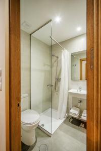 a bathroom with a shower and a toilet and a sink at Hostal-Restaurante LUGANO in Verín
