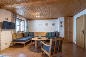 a living room with a couch and a table at Ferienhaus Bach Gotthard in Pfronten