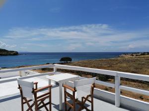 a table and two chairs on a balcony with the ocean at Sunset Studios & Rooms in Antiparos