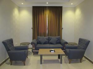 sala de estar con sofá, 2 sillas y mesa en Lavent Park en Yeda