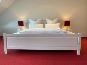 ein Schlafzimmer mit einem weißen Bett mit zwei Lampen in der Unterkunft Familien-Suite in Villa in Hildesheim