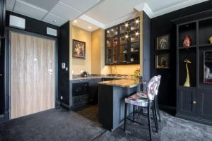 a kitchen with black walls and a bar with a chair at Prymasa Tysiąclecia 83A by Homeprime in Warsaw