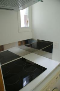 una cocina con fogones negros en una encimera en Appartement L'Hivernelle, en Capvern