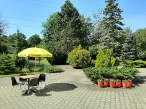 a table and chairs with an umbrella in a garden at Lenas West Hotel in Vienna