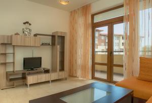 a living room with a flat screen tv and a couch at Garden of Eden PMG Apartments in Sveti Vlas