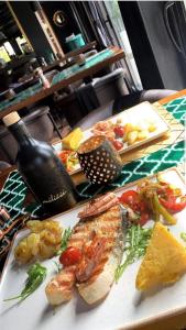 a table with a plate of food and a bottle of wine at Hotel Boutique Bristol in Sarajevo