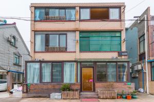 a tall brick building with glass windows on a street at Nancy Guesthouse in Shanghai