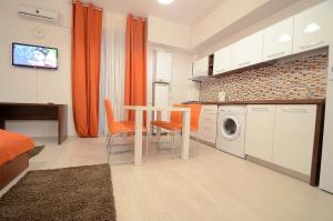 a kitchen with a table and a washing machine at Uptown Residence Apartments in Bucharest