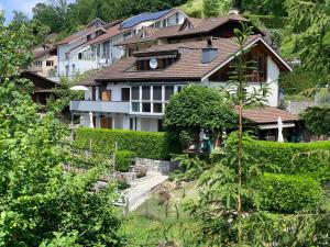 ein großes Haus auf einem Hügel mit Büschen in der Unterkunft apartment Monte Castello in Wolhusen