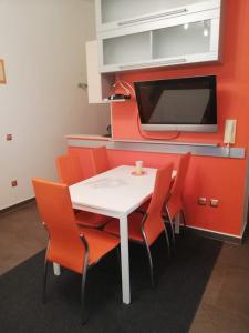 une salle à manger avec une table blanche et des chaises orange dans l'établissement Apartment Adriana, à Povljana