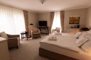 a hotel room with a bed and a desk and chairs at Strandhotel Fontana in Timmendorfer Strand