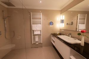 a bathroom with a sink and a shower at Strandhotel Fontana in Timmendorfer Strand