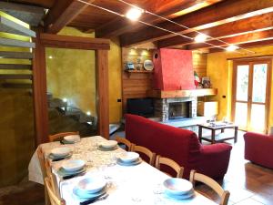 una sala da pranzo con tavolo e sedie e una cucina di La Dolce Vita chalet a Massino Visconti
