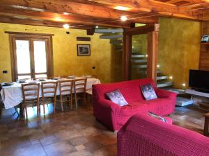 a living room with a table and a red couch at La Dolce Vita chalet in Massino Visconti