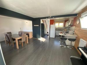 a kitchen and living room with a table and chairs at La Maison d'Arsène in Le Mans