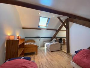 Zimmer im Dachgeschoss mit 2 Betten und einem Fenster in der Unterkunft La Maison d'Arsène in Le Mans