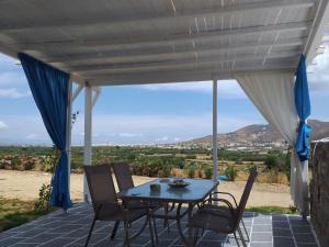 a table and chairs on a patio with a view at Naxian vacation with sea view in Naxos Chora