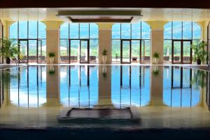 a large swimming pool in a building with windows at Hyatt Regency Pravets Resort in Pravets