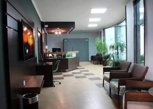 a lobby with chairs and tables in a building at Forest Hotel in Porto Velho