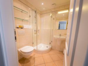 a bathroom with a toilet and a shower and a sink at Strandhotel Fontana in Timmendorfer Strand