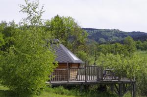 a cabin in the middle of a field with trees at Les Roulottes et Cabanes du Livradois in Cunlhat