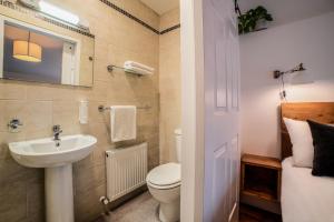 La salle de bains est pourvue de toilettes blanches et d'un lavabo. dans l'établissement Black Cat, à Galway