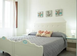 una camera da letto con un letto bianco con due cuscini sopra di Stella Guest House a Santa Teresa di Gallura