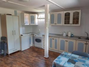 a kitchen with white cabinets and a table in a room at LUNA nad jeziorem Wojnówko gm Murowana Goślina in Wojnówko +18 photos