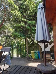 una sombrilla sentada en una mesa en un patio en LUNA nad jeziorem Wojnówko gm Murowana Goślina, en Wojnówko