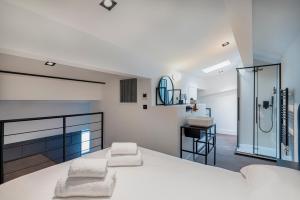 een slaapkamer met een wit bed en een badkamer bij RESIDENCE MONTEFIORE in Cannes