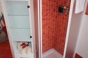 a bathroom with a shower with red tile at Le Margherite in Cardano al Campo