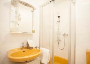 a bathroom with a yellow sink and a shower at Appartement Casa Waltenberg Winterberg in Winterberg