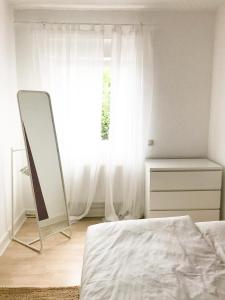 a bedroom with a bed and a mirror and a window at Dream Green Apartment 'Frida' in Gladenbach