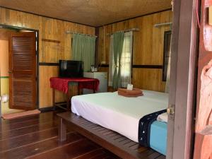 una camera con un letto e una televisione di Sam's House Kanchanaburi a Kanchanaburi