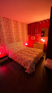 una camera da letto con un grande letto con illuminazione rossa di B&B Dolce Sogno a SantʼElpidio a Mare