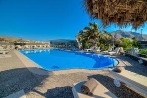 a swimming pool with lounge chairs and a resort at Pantheon Hotel in Perivolos