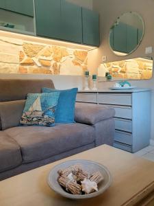 ein Wohnzimmer mit einem Sofa und einem Tisch in der Unterkunft Deluxe Apartment near the Airport Adults Only in Porto Rafti
