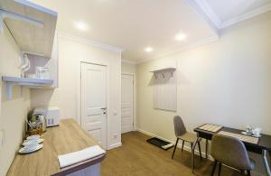 a small kitchen with a table and chairs in a room at ROSSI HOTEL in Tver