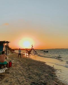 a group of people on the beach at sunset at Casa Branca in Atins +10 photos