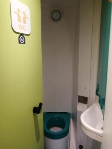 W łazience znajduje się zielona toaleta i umywalka. w obiekcie hotelF1 Epinay sur Orge w mieście Épinay-sur-Orge