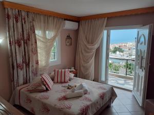 a bedroom with a bed and a large window at Athanasia Rooms in Maries