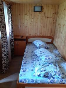 a bedroom with a bed with blue and white sheets at Pastravaria Romani in Horezu