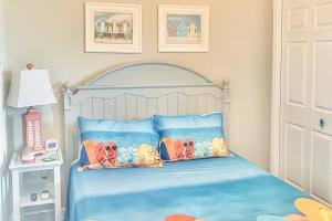 a bedroom with a blue bed with two pillows at Sterling Reef in Panama City Beach