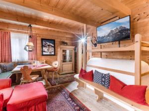 a bedroom with a bunk bed and a dining room at Chalets Berglehen in Sankt Johann in Tirol