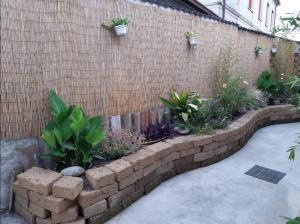 a brick retaining wall with plants on it at B&B La Mandragola in Berra