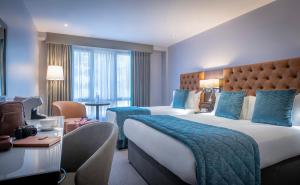 a hotel room with two beds with blue pillows at Grand Canal Hotel in Dublin