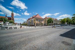 une rue vide dans une ville avec des bâtiments et une église dans l'établissement Rint - Centrum Sienkiewicza, à Białystok