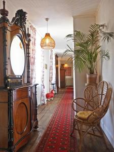a hallway with a dresser and chairs and a mirror at Maison de Fortitude Chambres d'hotes in Salviac