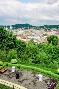 a group of people sitting on a bench in a park at Citadel Inn Gastro Boutique Hotel in Lviv